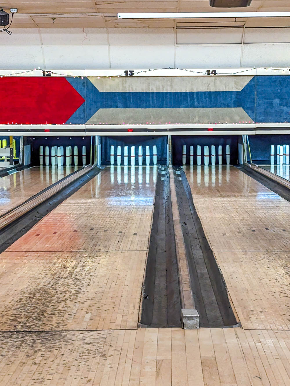 candlepins standing up at the end of a bowling lane in south boston